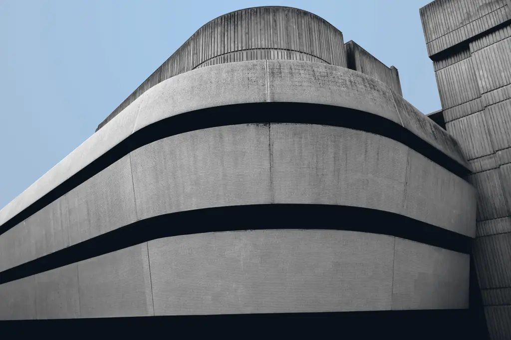 Architecture contemporaine en béton, volumes courbes sous un ciel clair